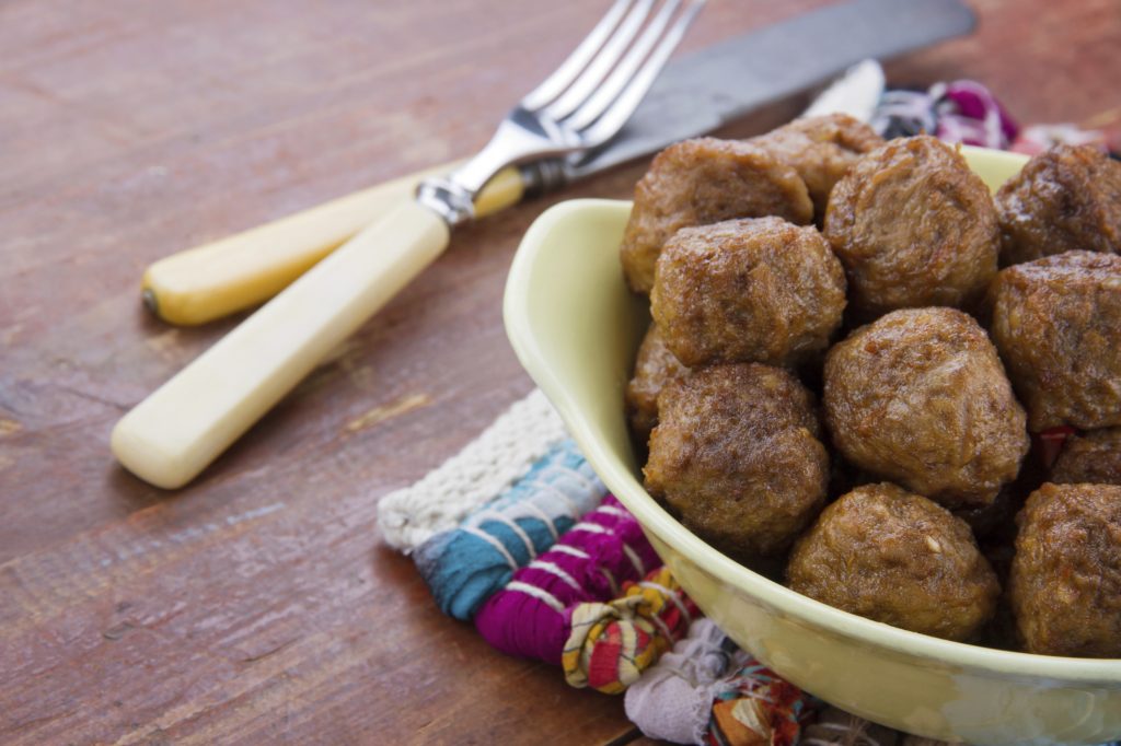 Rustic table with bowl of meatballs